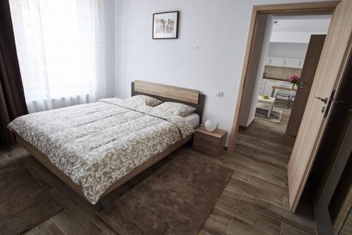 a bedroom with a bed with a white comforter at AT Central Apartments in Bucharest
