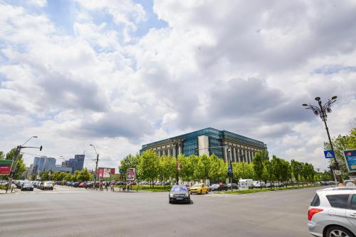 a parking lot with cars parked in front of a building at AT Central Apartments in Bucharest