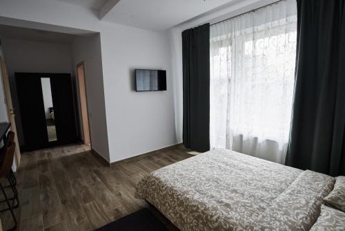 a bedroom with a bed and a large window at AT Central Apartments in Bucharest
