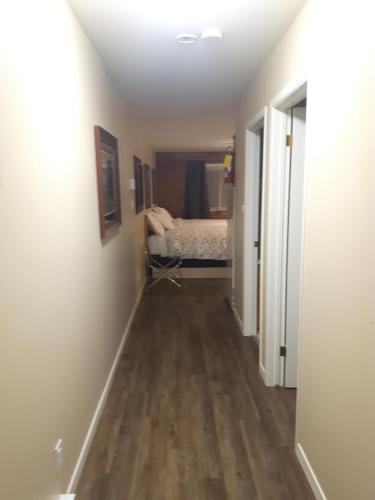 a hallway leading to a bedroom with a bed at Fair Isle Motel & The Nest in Whycocomagh