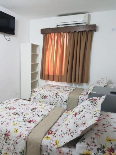a bedroom with two beds and a window at Hotel Morada do Mar in Guarujá