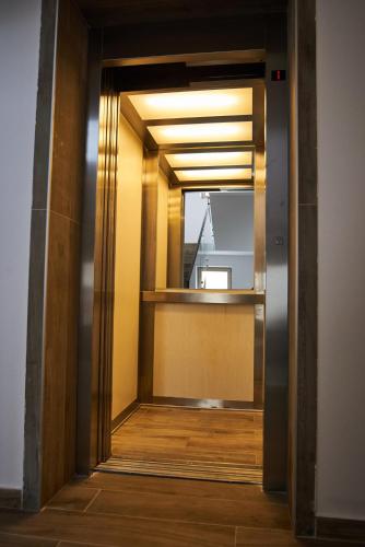a hallway with a mirror and a door with a window at AT Central Apartments in Bucharest