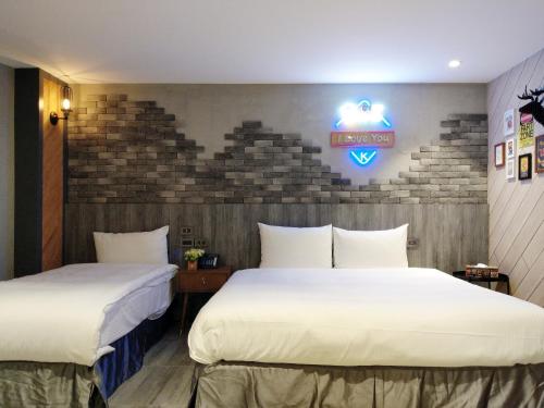 a hotel room with two beds and a sign on the wall at K HOTEL in Taichung