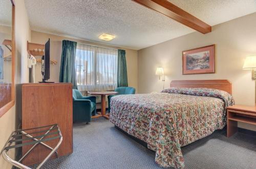 a hotel room with a bed and a desk at Redmond Inn in Redmond