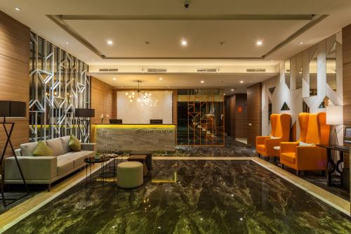 a lobby with orange chairs and a marble floor at Sahid Serpong in Serpong
