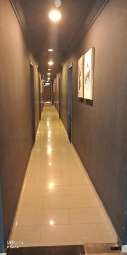 a long hallway with a tile floor in a building at T Hotel Johor Bahru in Skudai