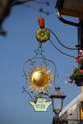a chandelier with a sunflower and a sign on it at Weinhotel / Gasthaus zur Sonne in Ihringen