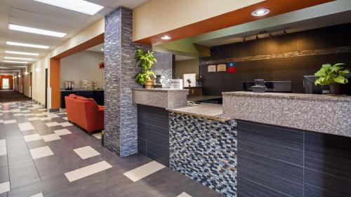 a lobby of a hotel with a reception counter and a lobby at SureStay Plus Hotel by Best Western Blue Springs in Blue Springs