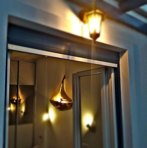 a window with a reflection of a boat in the mirror at Enjoy Cyclades studios & suites in Kithnos