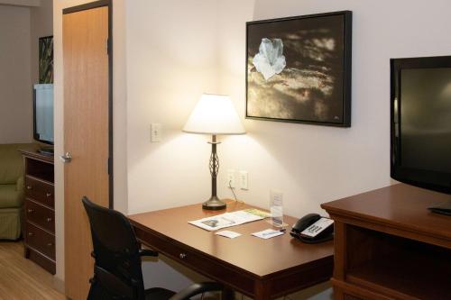 a hotel room with a desk with a lamp and a phone at Best Western I-5 Inn & Suites in Lodi