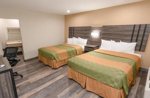 una camera d'albergo con due letti e una scrivania di Crown Motel a El Centro