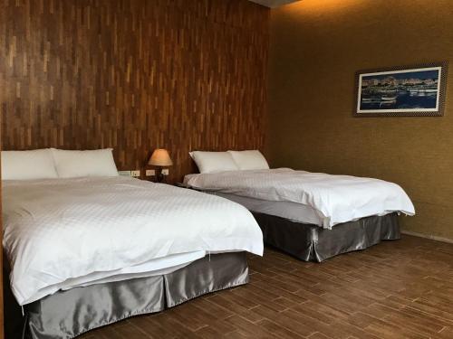 a room with two beds in a hotel room at Hiye Fashion Motel in Dounan