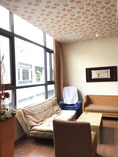 a living room with a couch and a chair at Hiye Fashion Motel in Dounan