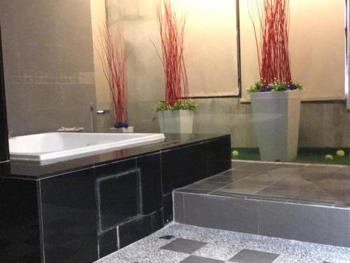 a bathroom with a white sink and red plants at Hiye Fashion Motel in Dounan