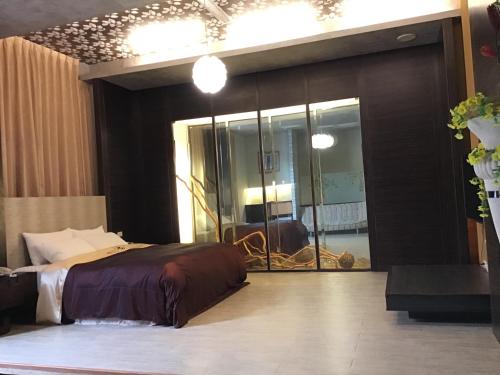a bedroom with a bed and a large mirror at Hiye Fashion Motel in Dounan