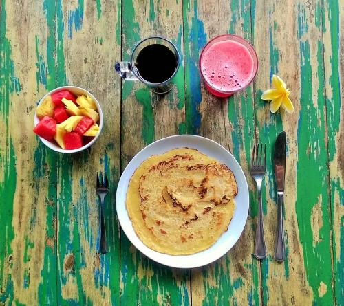 un tavolo con una ciotola di frutta e un piatto di salsa di Namaste Bungalows a Nusa Penida