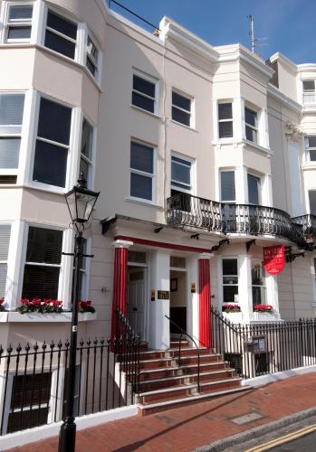 a white house with a balcony on a street at New Steine Hotel - B&B in Brighton & Hove