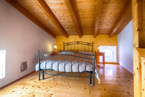 1 dormitorio con 1 cama en una habitación con techos de madera en Agriturismo Revena en Belluno Veronese