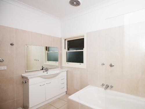 a white bathroom with a sink and a tub and a sinkessment at Summer Cottage in Hawks Nest
