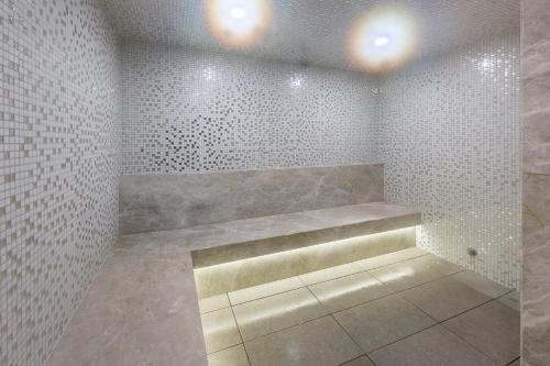 un bagno con pareti piastrellate bianche e una panca di Imagine Lighthouse a Melbourne