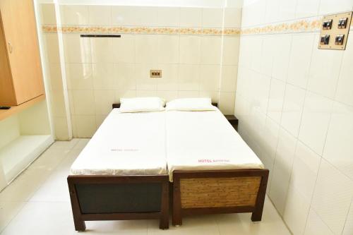 a small room with a bed in a bathroom at Hotel Ganesh Lodge in Kanyakumari