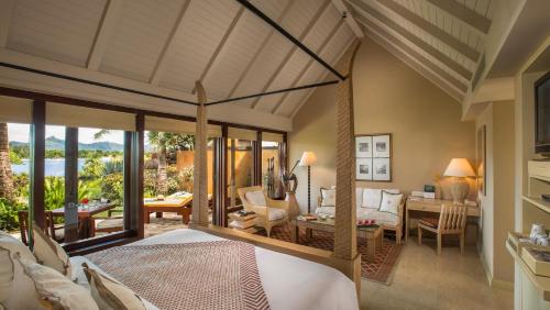 a bedroom with a bed and a living room at The Oberoi Beach Resort, Mauritius in Balaclava