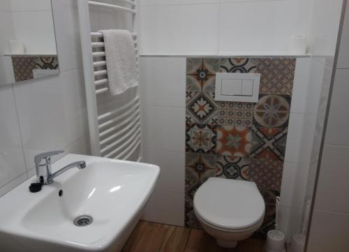 uma casa de banho com um lavatório branco e um WC. em Hostel Bed - Breakfast Brno em Brno