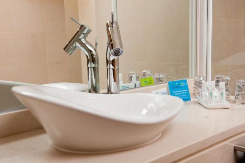 a white sink sitting on a counter in a bathroom at Atlantida Mar Hotel in Praia da Vitória