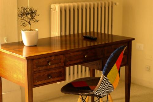 a wooden desk with a plant and a chair at 4 Balconi rooms-Boutique B&B in Lecce