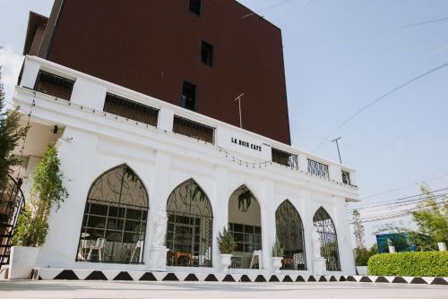 a white building with a brown building at PJ Loft Hotel in Ban Khok Krathin