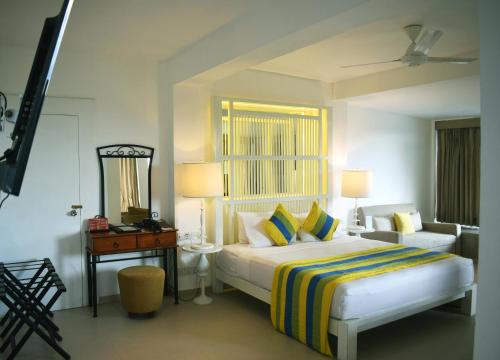 a bedroom with a bed and a dresser at Thilanka Hotel in Kandy