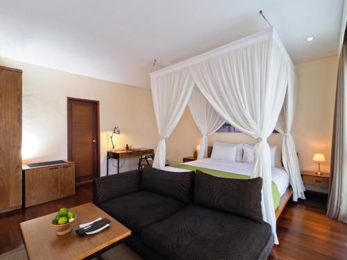 a living room with a bed and a couch at The Samata by LifestyleRetreats in Sanur
