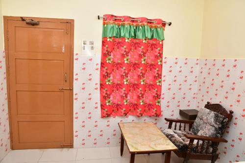 a room with a red curtain and a table at Hotel Ganesh Lodge in Kanyakumari