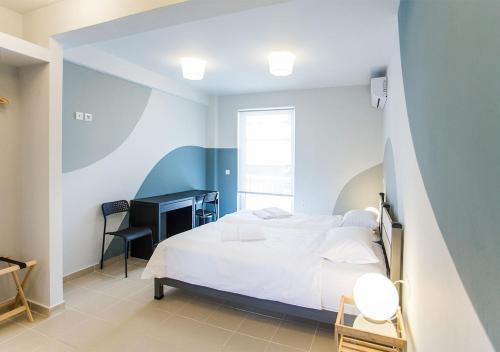a bedroom with a white bed and a desk at Snooze H in Athens