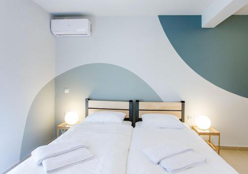 a large bed with two white pillows on it at Snooze H in Athens