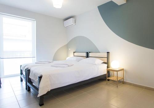 a bedroom with a large bed with white sheets at Snooze H in Athens