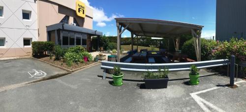a picnic table in a parking lot next to a building at hotelF1 La Rochelle Angoulins "Rénové" in Angoulins