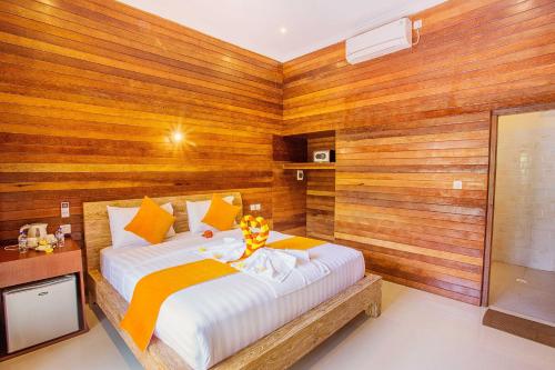 a bedroom with a large bed and wooden walls at Dinatah Lembongan Villas in Nusa Lembongan