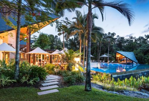 a resort with a swimming pool and palm trees at Niramaya Villas and Spa in Port Douglas