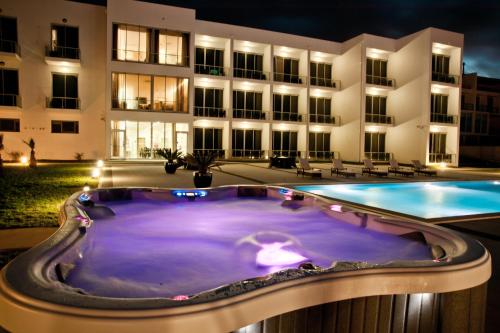 a pool in front of a building at night at Atlantida Mar Hotel in Praia da Vitória