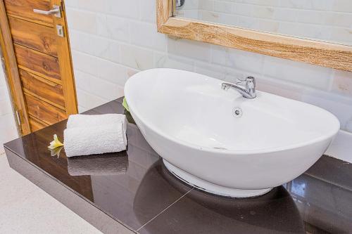 a bathroom with a white sink and a mirror at Dinatah Lembongan Villas in Nusa Lembongan