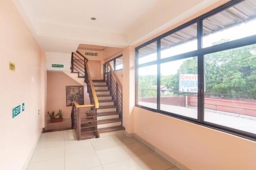 a hallway with a staircase and a large window at CounTess Pension House in Liloan