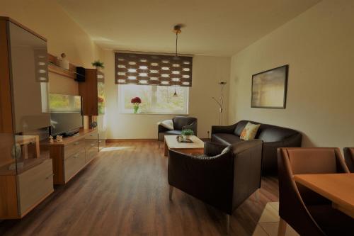 a living room with two couches and a television at Ferienwohnungen Auf der Düne in Cuxhaven