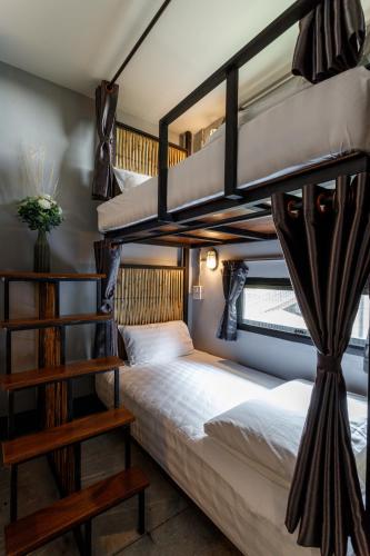 a bedroom with two bunk beds and a staircase at Hostel One Art and Gallery in Chiang Mai