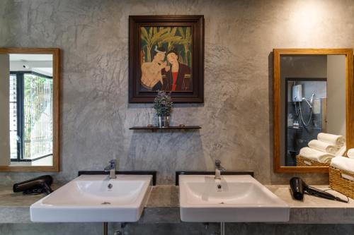 two sinks in a bathroom with two mirrors at Hostel One Art and Gallery in Chiang Mai