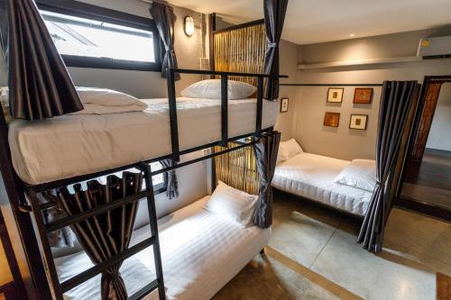 a room with three bunk beds in a room at Hostel One Art and Gallery in Chiang Mai