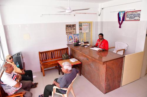 a group of people sitting in a waiting room at Hotel Ganesh Lodge in Kanyakumari