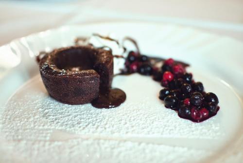 a plate with a chocolate cake and berries on it at Restaurace a Penzion Praha in Dolní Dunajovice