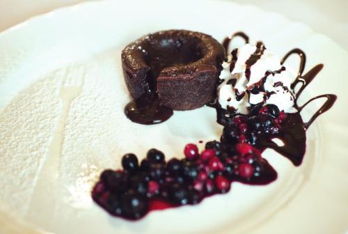 a piece of chocolate cake and berries on a plate at Restaurace a Penzion Praha in Dolní Dunajovice