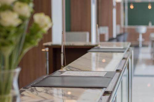 a glass counter in a room with flowers on it at Justice Hotel in Bangkok